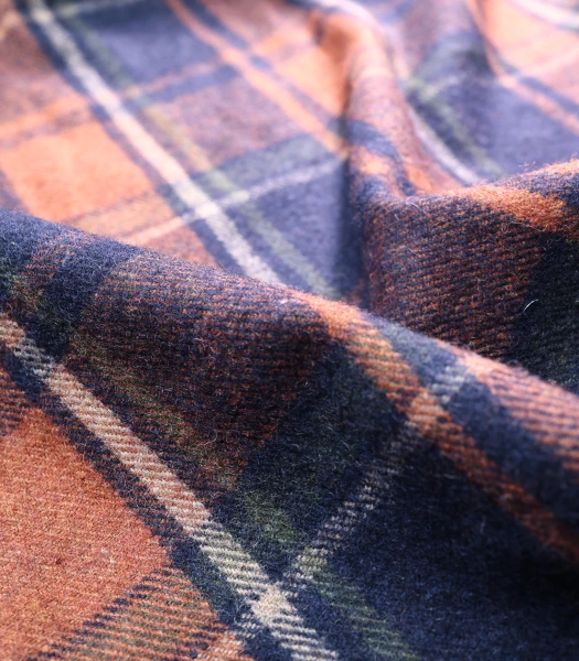 wool fabric in a warm plaid of orange, navy blue, and green